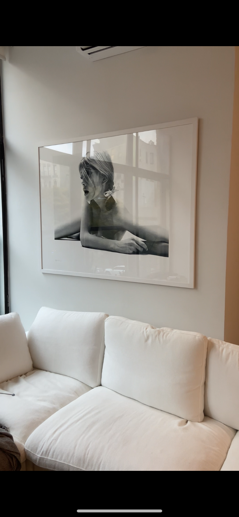 Perfectly mounted frame above a sofa, thanks to our handyman in nyc.