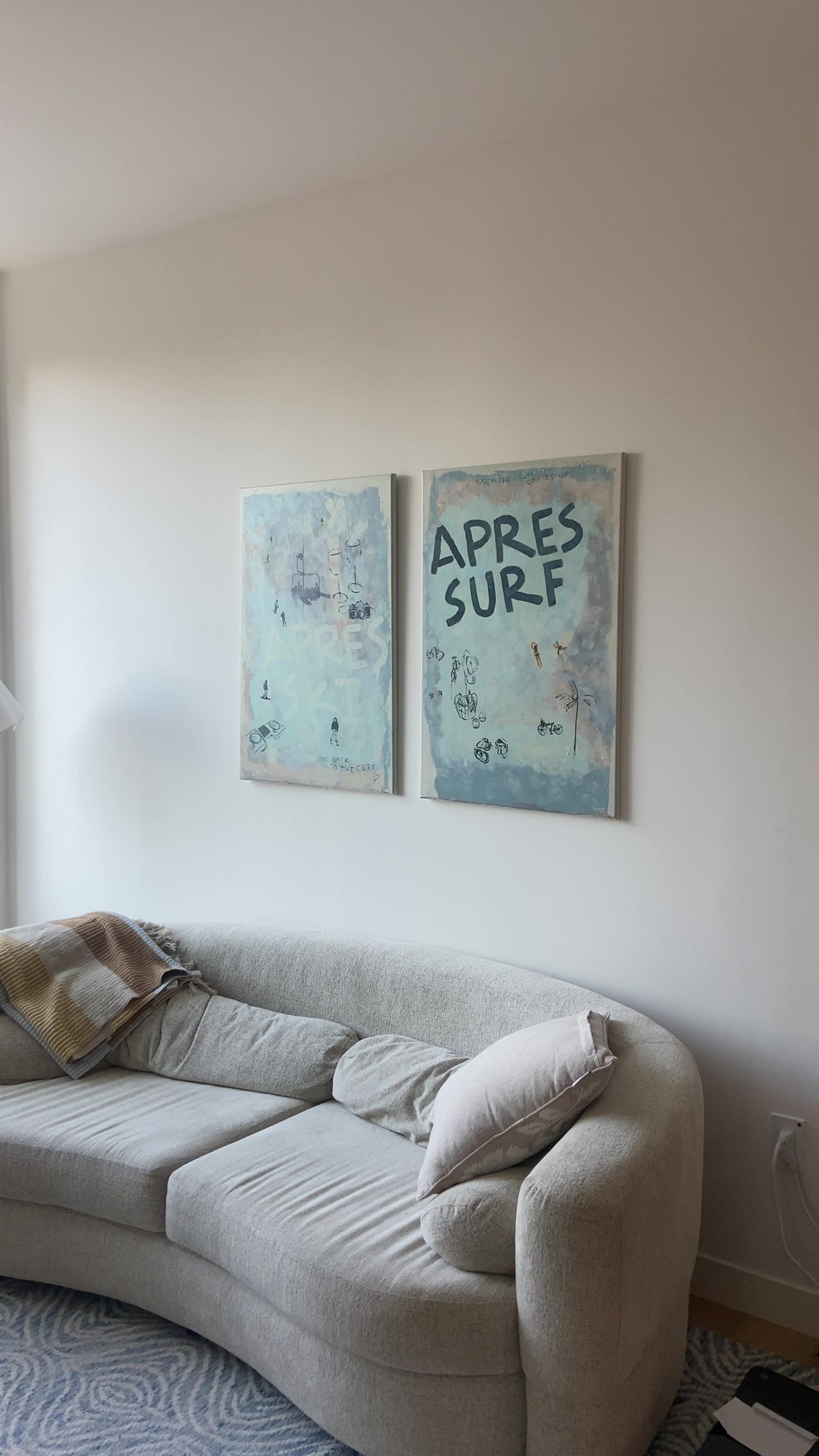 After: Apres Surf canvas pair hung level above a curved sofa