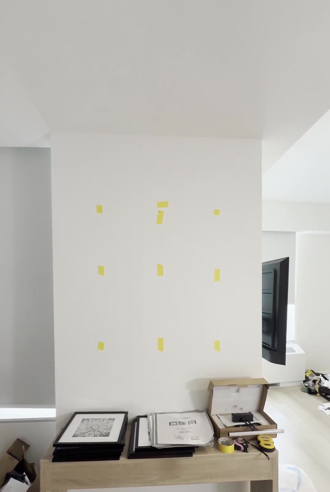 Before: blank wall marked with tape for a six-frame grid