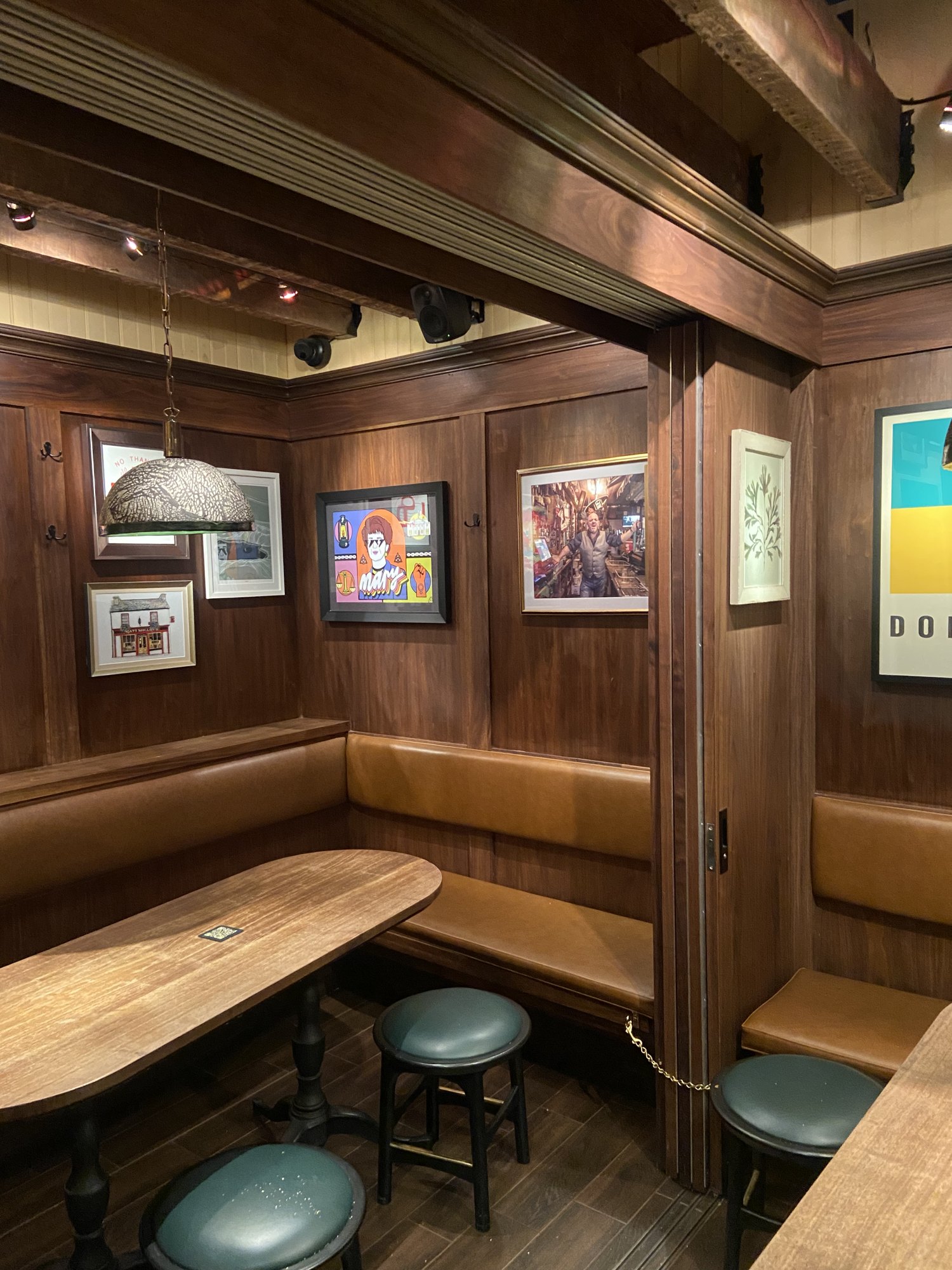 Framed prints installed in the wood-paneled booths at The Dead Rabbit, FiDi