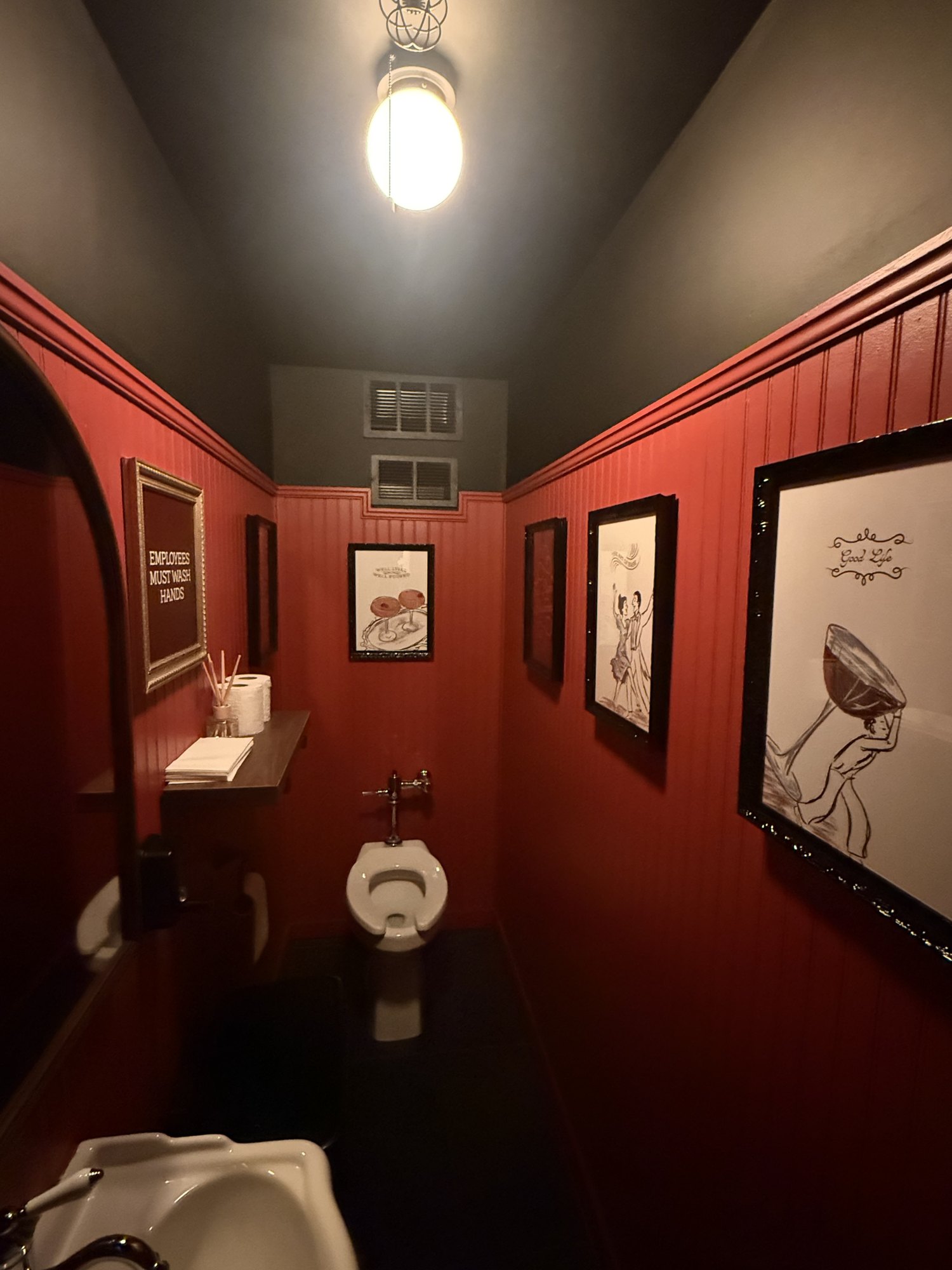 Framed art hung in a red powder room